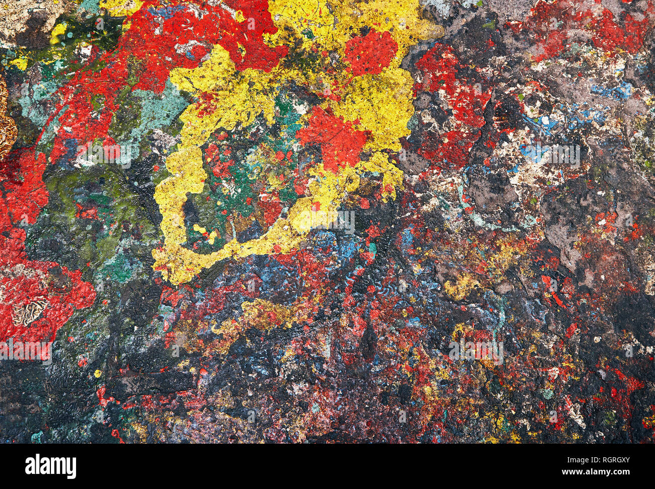 Spots der Farbe Rot, Gelb, Blau und andere Farben sind wahllos auf Beton verschüttet und bilden eine Zusammenfassung Hintergrund Stockfoto