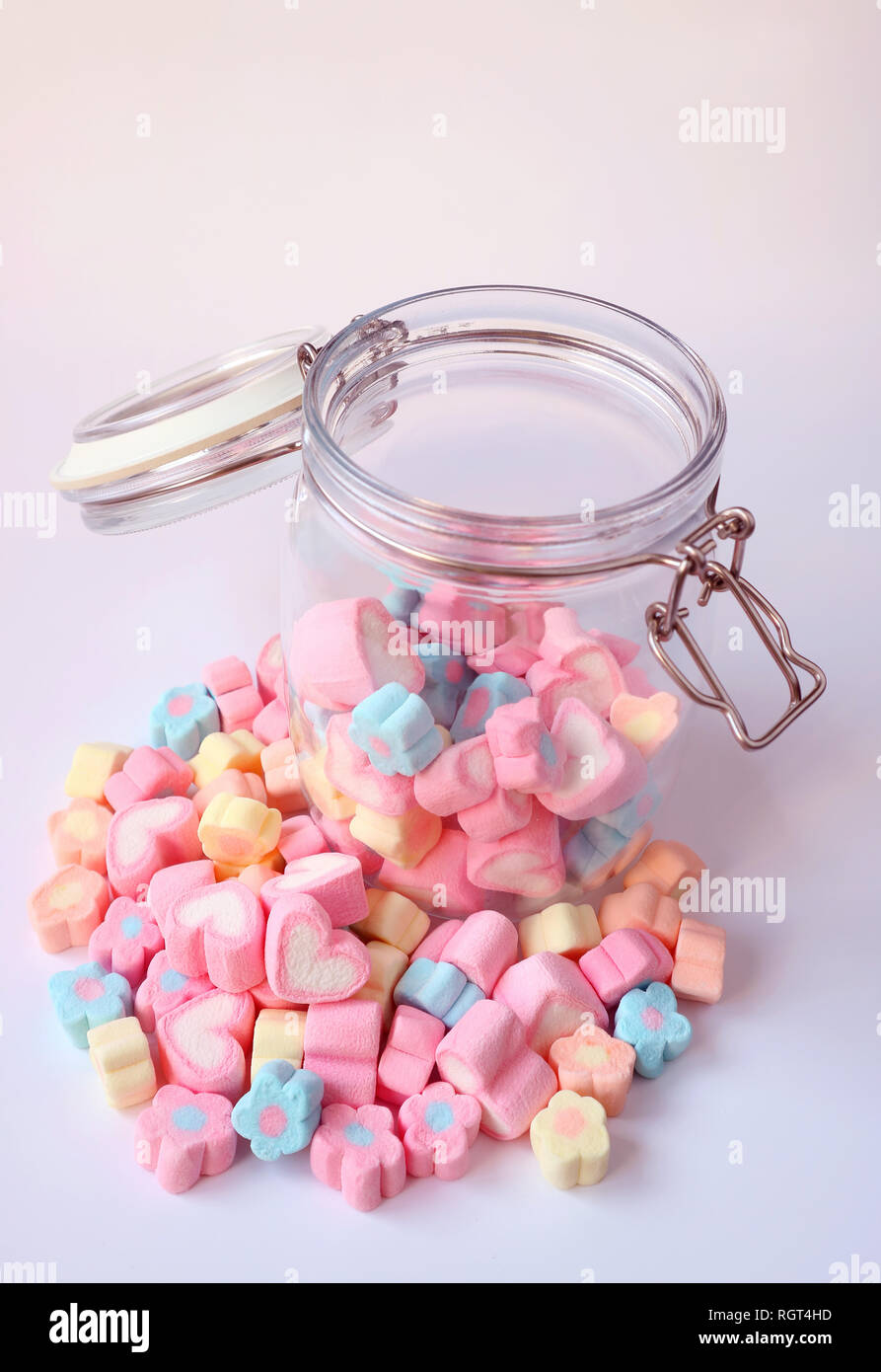 Haufen von Pastelltönen Marshmallow Bonbons auf Lila Tabelle mit einigen im geöffneten Glas, Valentine, Konzept Stockfoto