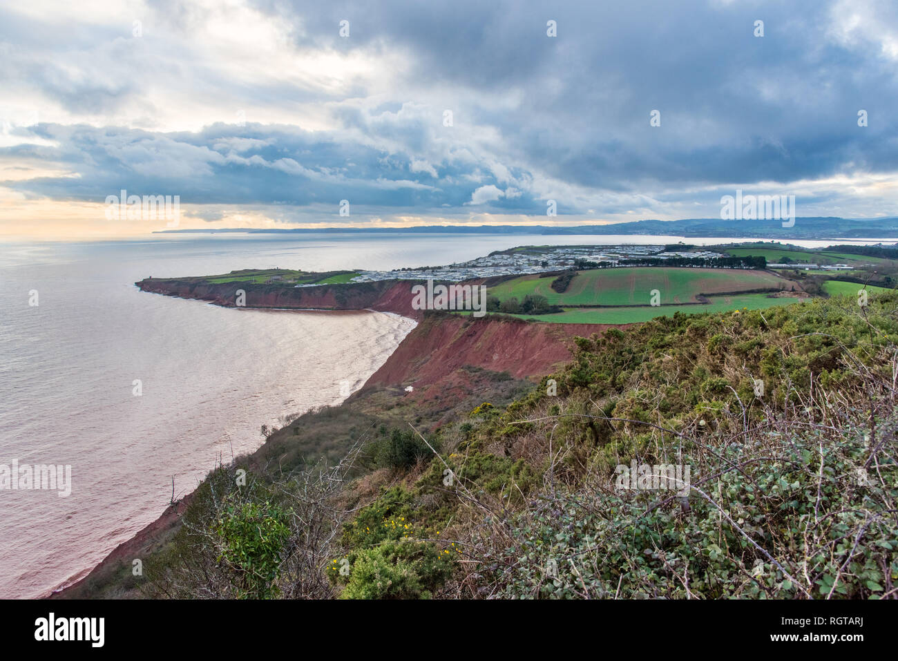 EXMOUTH, Devon, Großbritannien - 17 Jan 2019: Ansicht der Trias aus rotem Sandstein Straight Point und Teil des Devon Cliffs Holiday Park. Von Westen, Rundumleuchte. Stockfoto