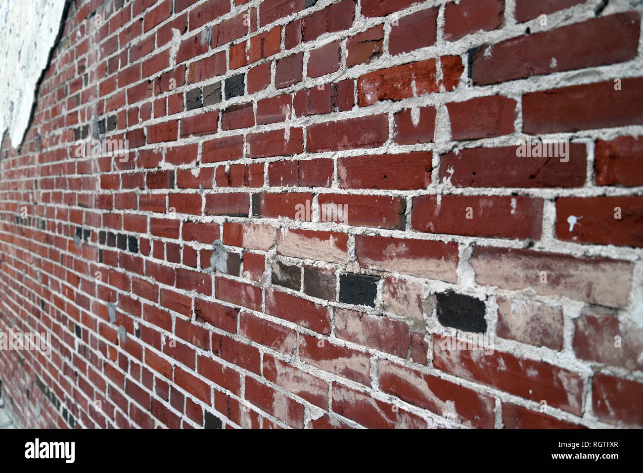 Lange Sicht auf Alte bemalte Ziegel und Mörtel Wand mit Gips und läuten Farbe, Hintergrund Textur Stockfoto