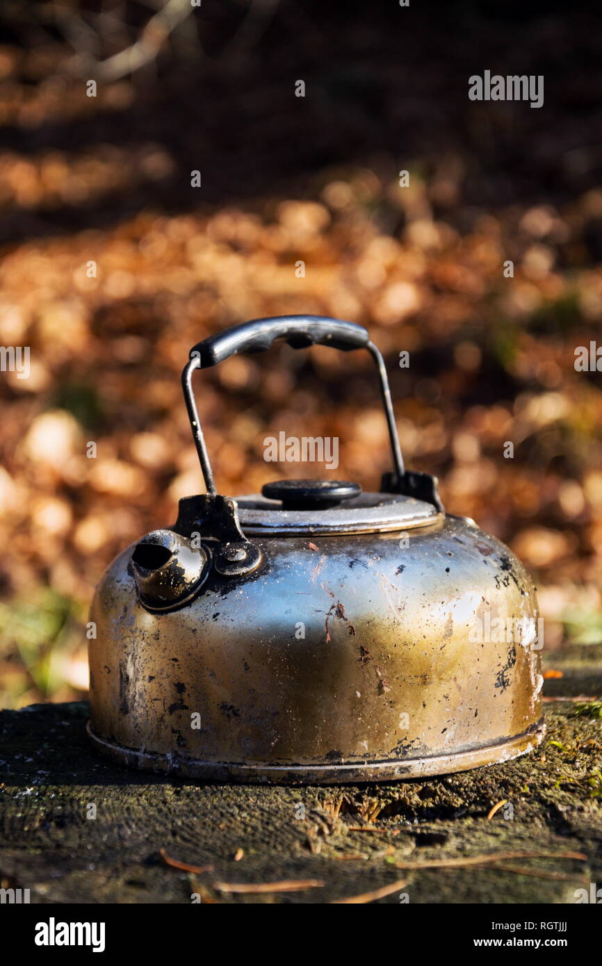 Geräucherter Zinn Kaffee Wasserkocher steht in Wald, Laub Natur Hintergrund, suny Herbst Tag Stockfoto