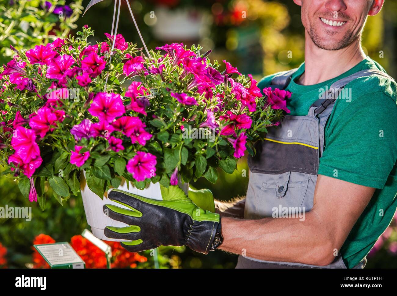 Happy kaukasischen Blumenhändler in seinem 30s mit Blumen Topf. Blumen Shop zufrieden. Stockfoto