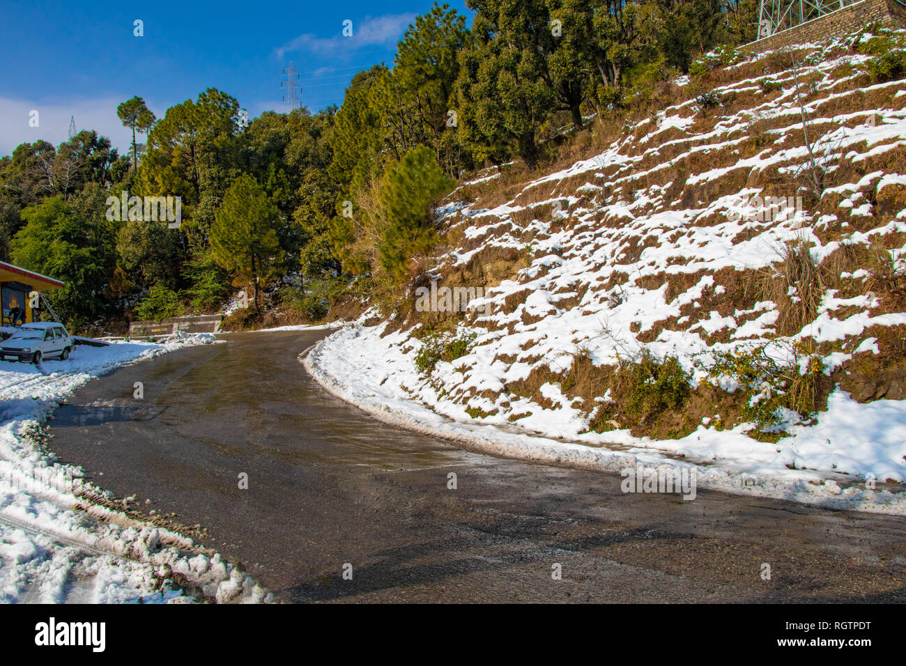 Landschaftlich reizvolle Straße durch das Tal von banikhet Dalhousie Himachal Pradesh mit Schnee Berge und Bäume abgedeckt. Bergauf scenic road winter Reisen c Stockfoto