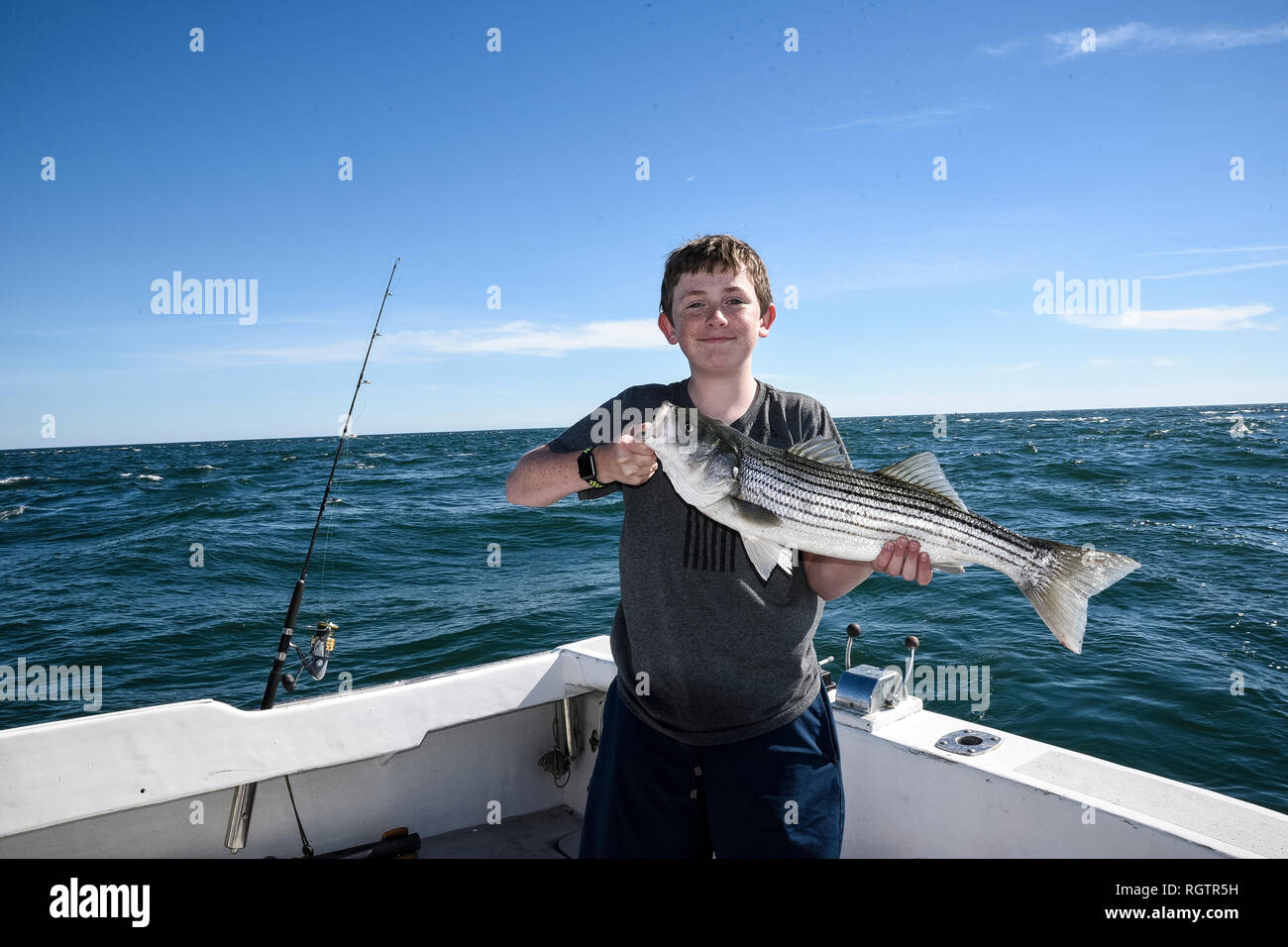 Stolz Junge mit Fisch auf Hochseefischen Ausflug erwischt. Stockfoto
