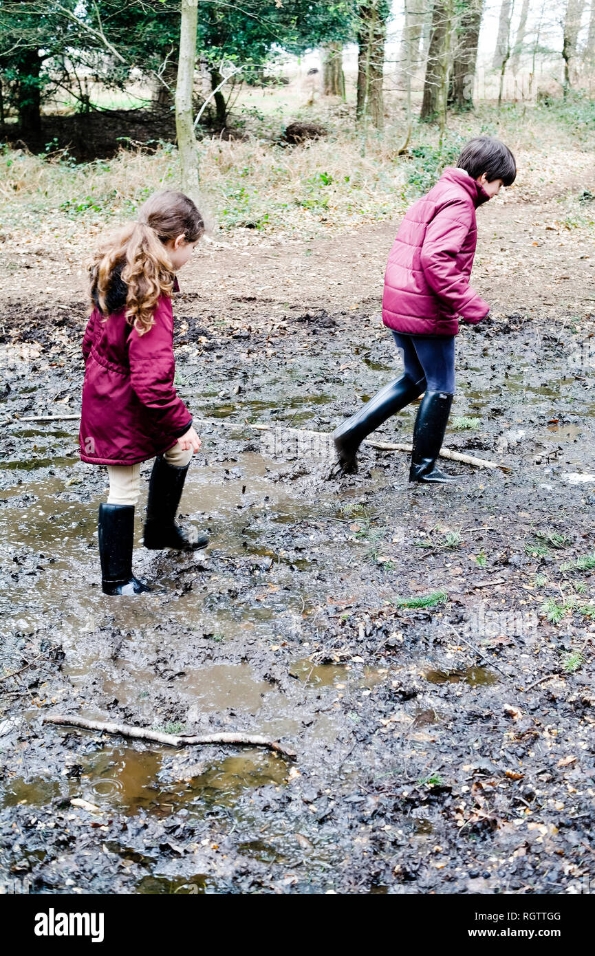 Kinder genießen einen schlammigen Weg im New Forest. Hampshire, Vereinigtes Königreich Stockfoto