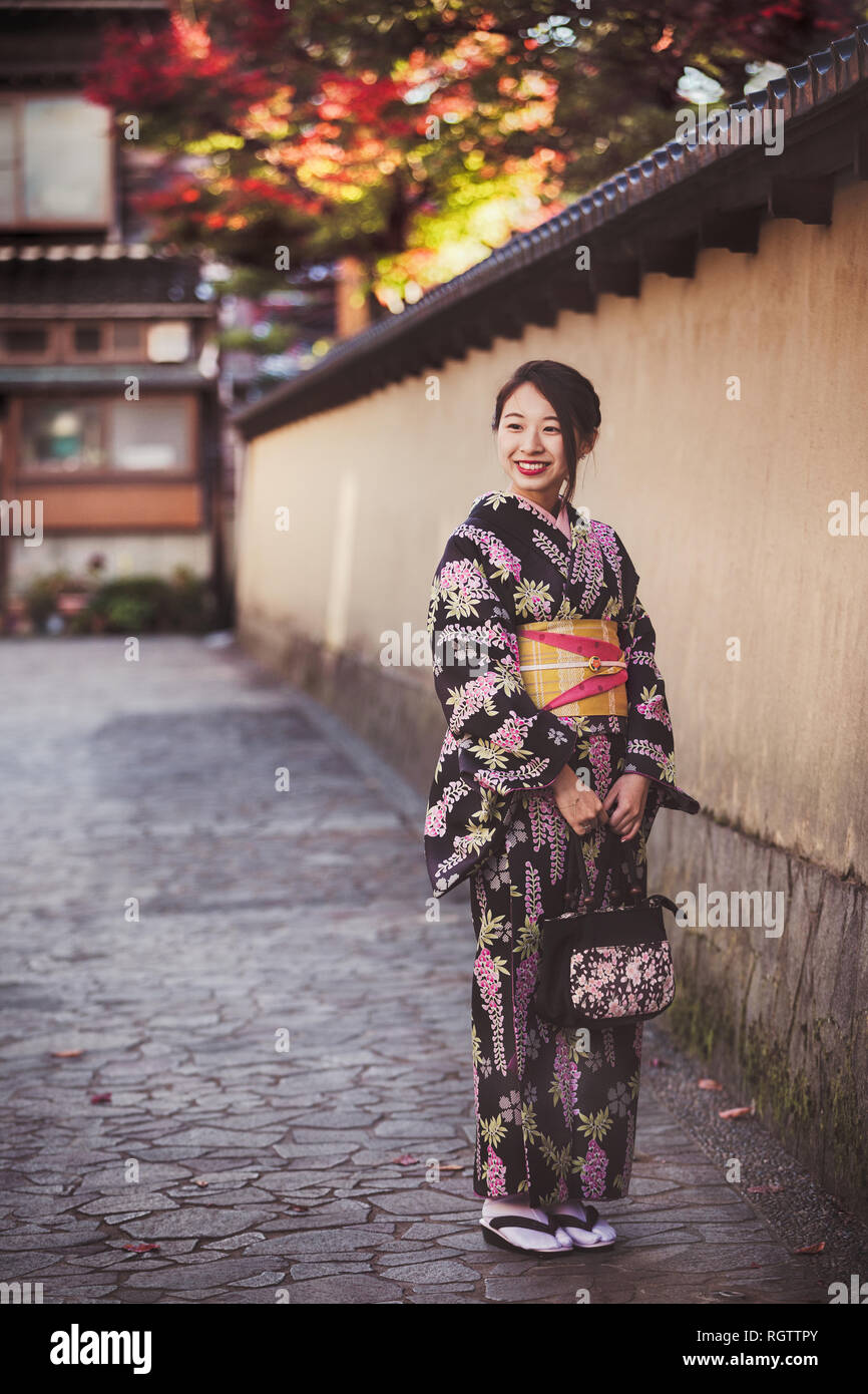 KANAZAWA, Japan - 28. NOVEMBER: japanische Mädchen im Kimono im Viertel Nagamachi Samurai posieren. Der Bereich Konserven samurai Residenzen, irdenen Wände, ent Stockfoto