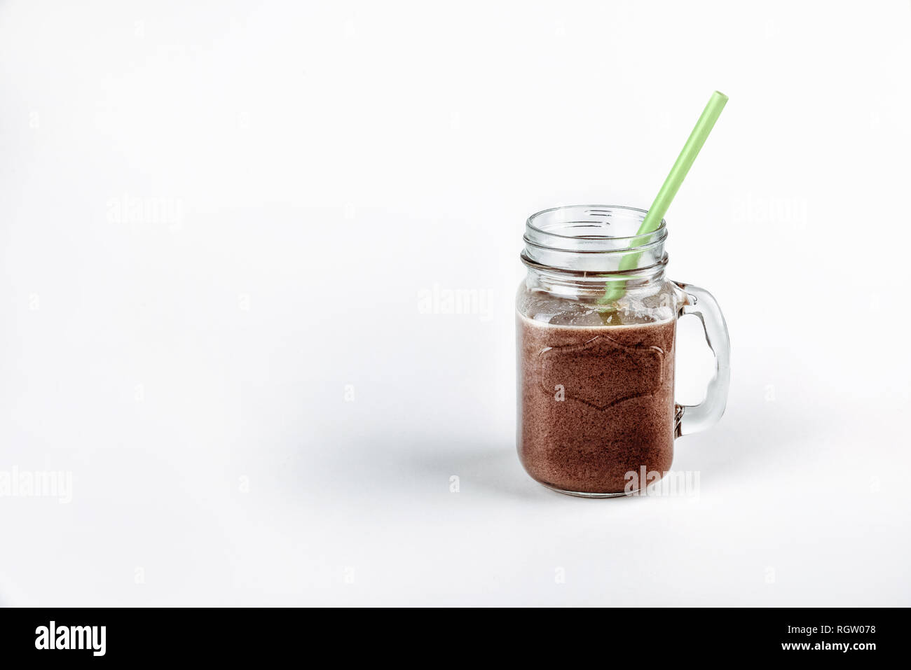 Kalte Schokolade Milchshake in einem Glas mit Strohhalm. frisches Eiweiß Stockfoto