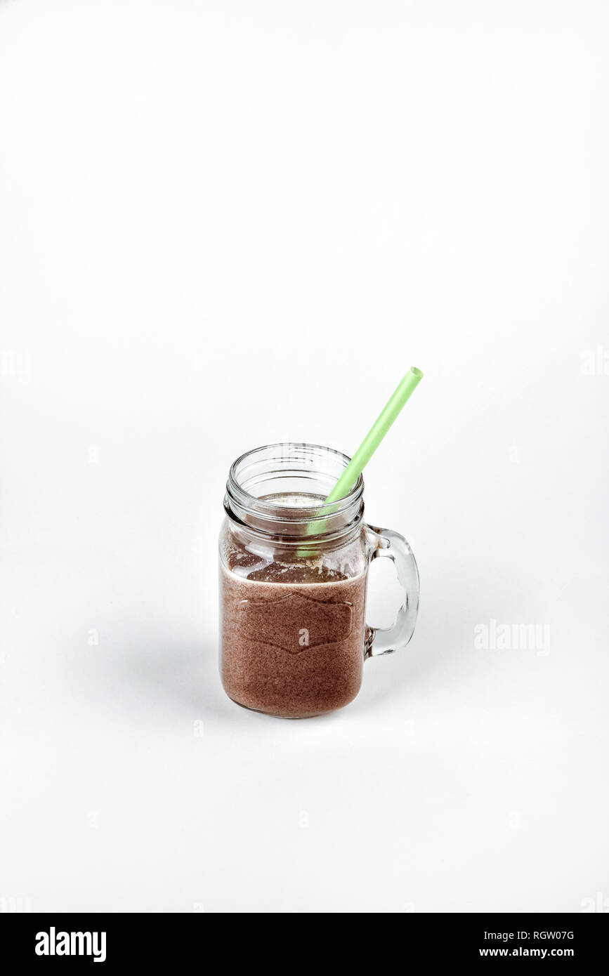 Kalte Schokolade Milchshake in einem Glas mit Strohhalm. frisches Eiweiß Stockfoto
