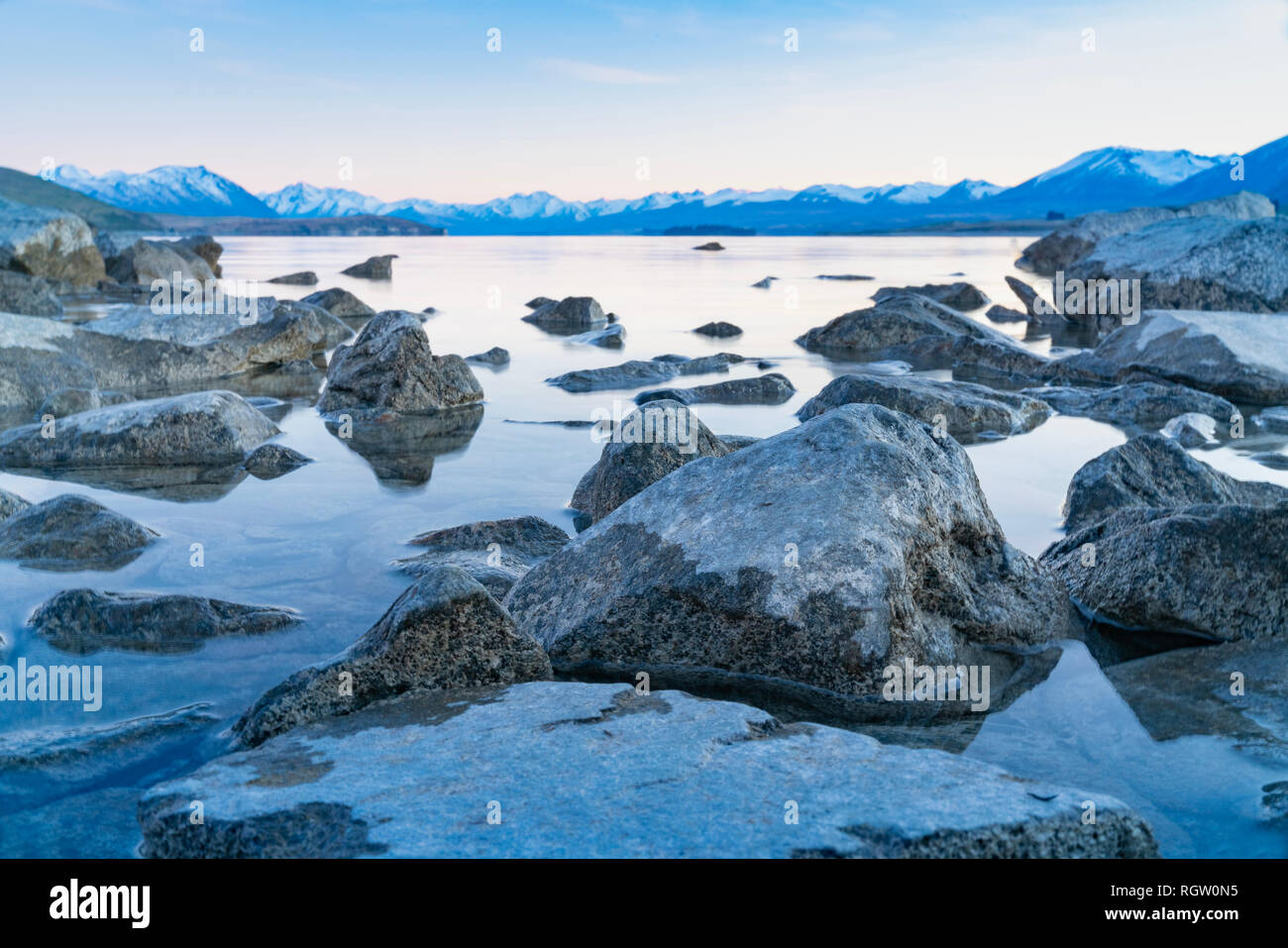 Lake Tekapo sunsise über felsige Küste und niedrigem Wasserstand der Ruhe ruhige See Stockfoto