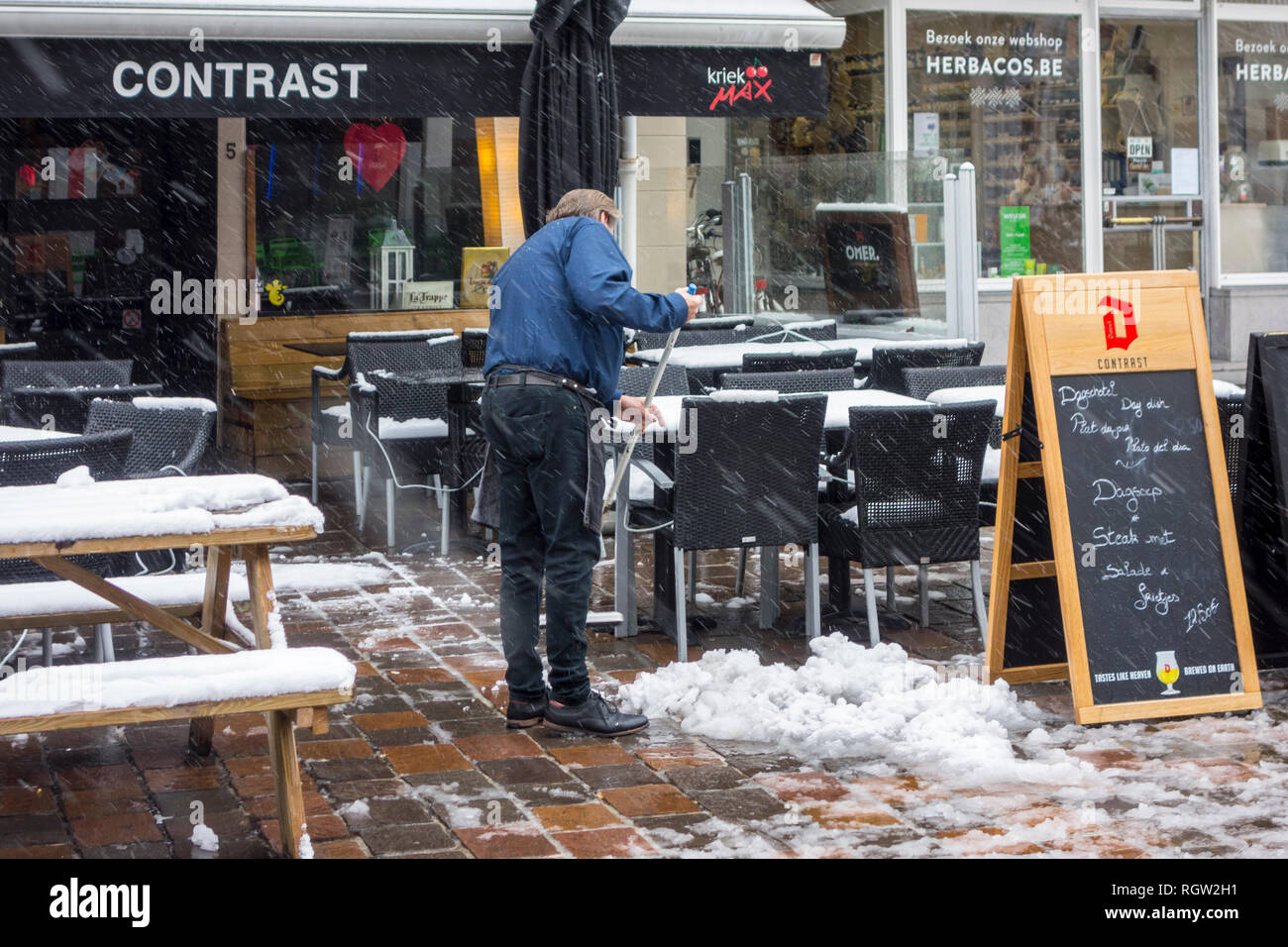 Restaurant/Pub besitzer Reinigung Cafe während Schneeregen/Schnee Dusche im  Winter in der Stadt Gent, Flandern, Belgien Stockfotografie - Alamy