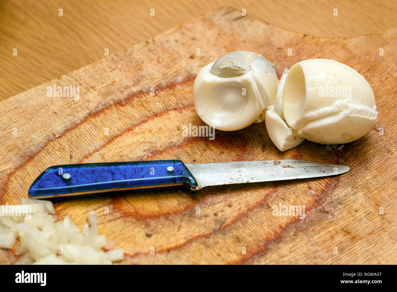 Gekochte Eier und ein Messer auf dem Schneidebrett in der Küche Stockfoto