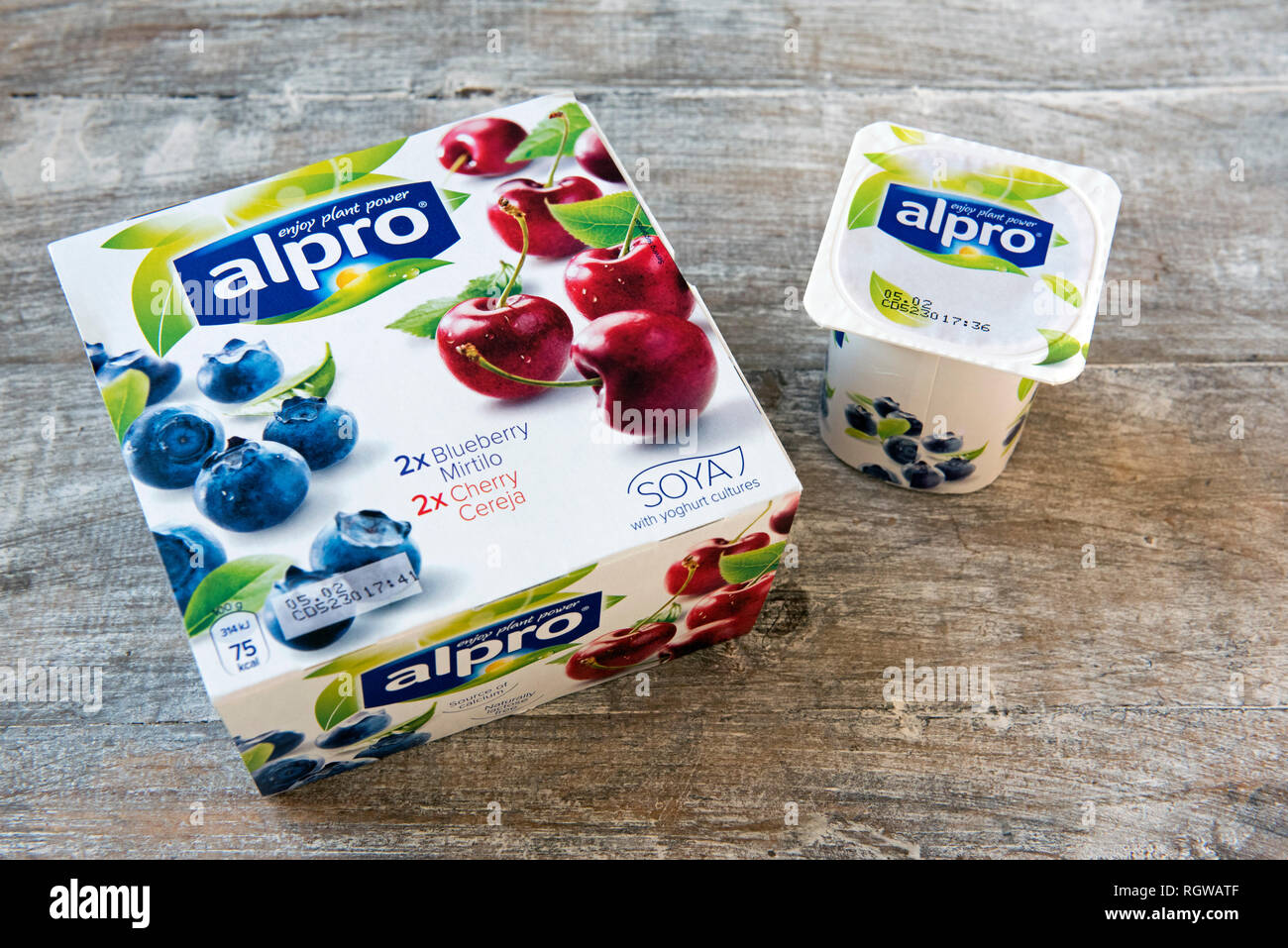 Paket von vegan Alpro soja Frucht Joghurt mit einem Joghurt Karton auf distressed Holz- Fach. Stockfoto
