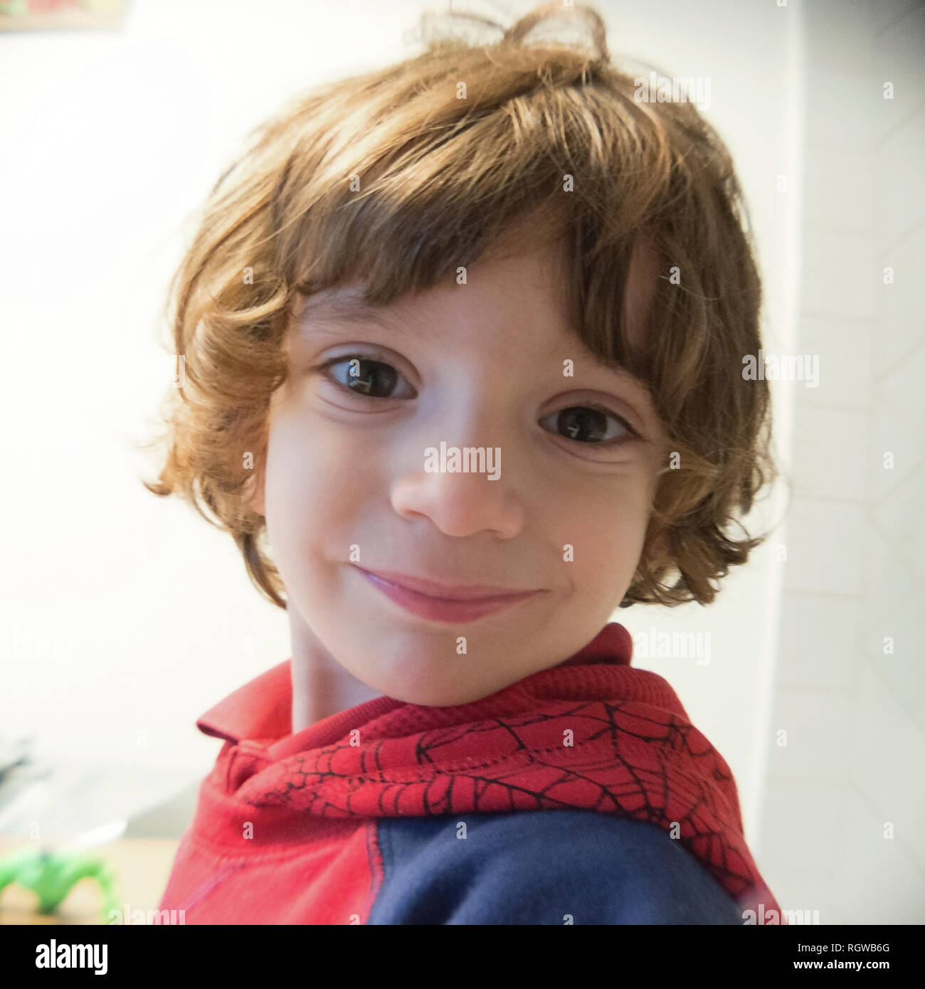Kind lächelnd und scherzen im Wohnzimmer Stockfoto