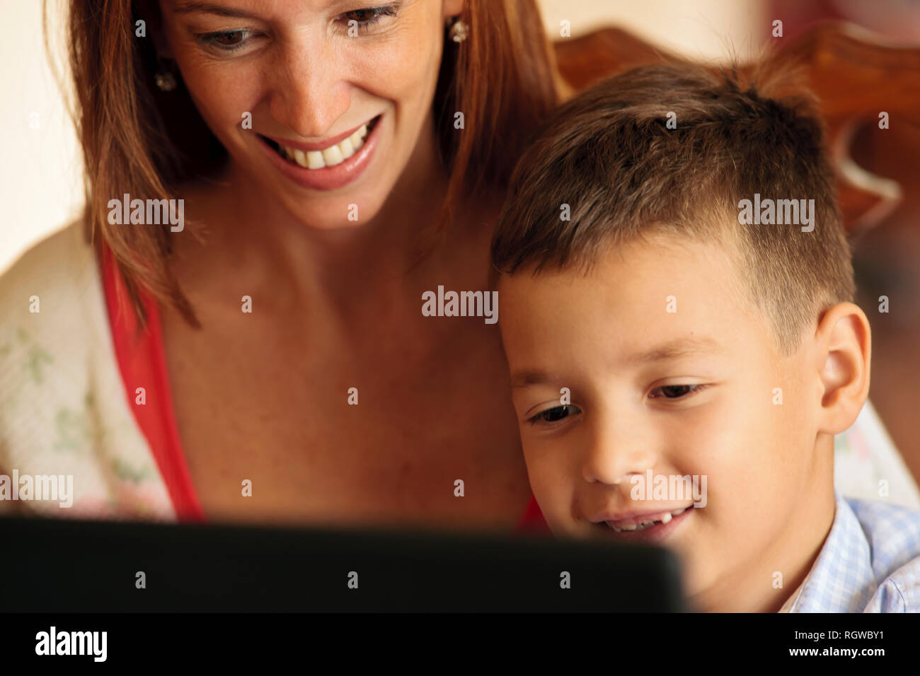 Junge und die Mutter auf der Suche nach Laptop Bildschirm. Stockfoto