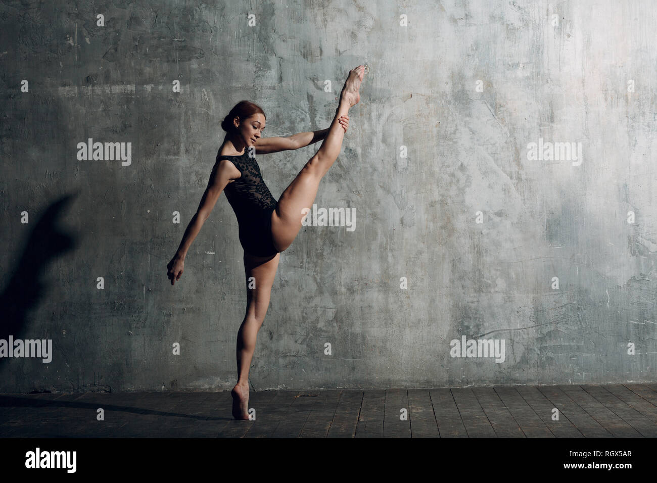 Ballerina ausdehnen. Junge schöne Frau Ballett Tänzerin, in professionellen  Outfit gekleidet, Spitzenschuhe und schwarzen Körper Stockfotografie - Alamy