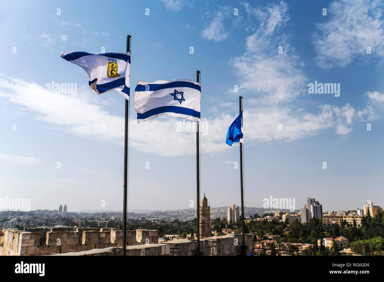 Israel und Jerusalem Flaggen über Jerusalem alte Stadtmauern gegen den blauen Himmel mit weißen Wolken im sonnigen Sommer. Stockfoto