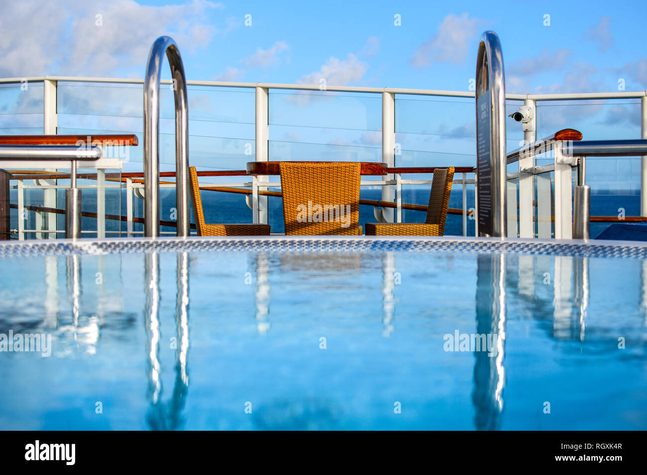Blick über eine unscharfe Whirlpool eine Tabelle für zwei in einem der oberen Deck Lounge eines Kreuzfahrtschiffes an einem sonnigen Tag. Stockfoto