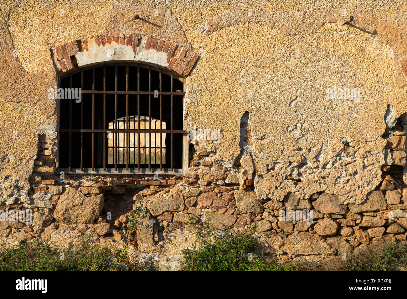 Ein Fenster eines alten Gebäudes oder Gefängnisses mit Bars am Fensterrahmen, auf der Insel Caprera, Sardinien, Italien. Stockfoto