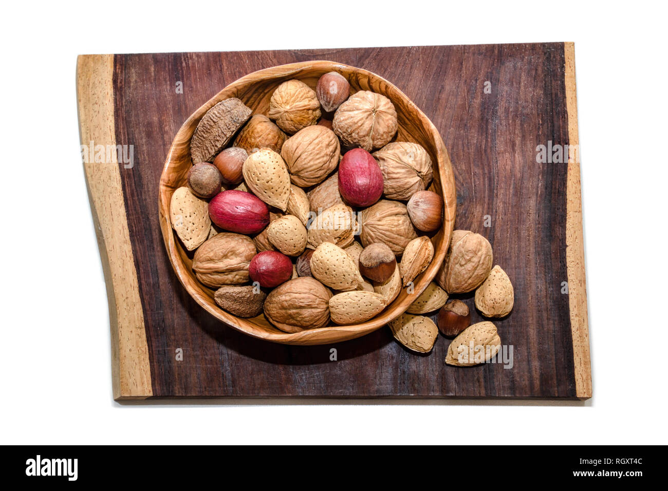 Gemischte Nüsse in Houten auf Stück exotischer Cola Bola Holz Stockfoto