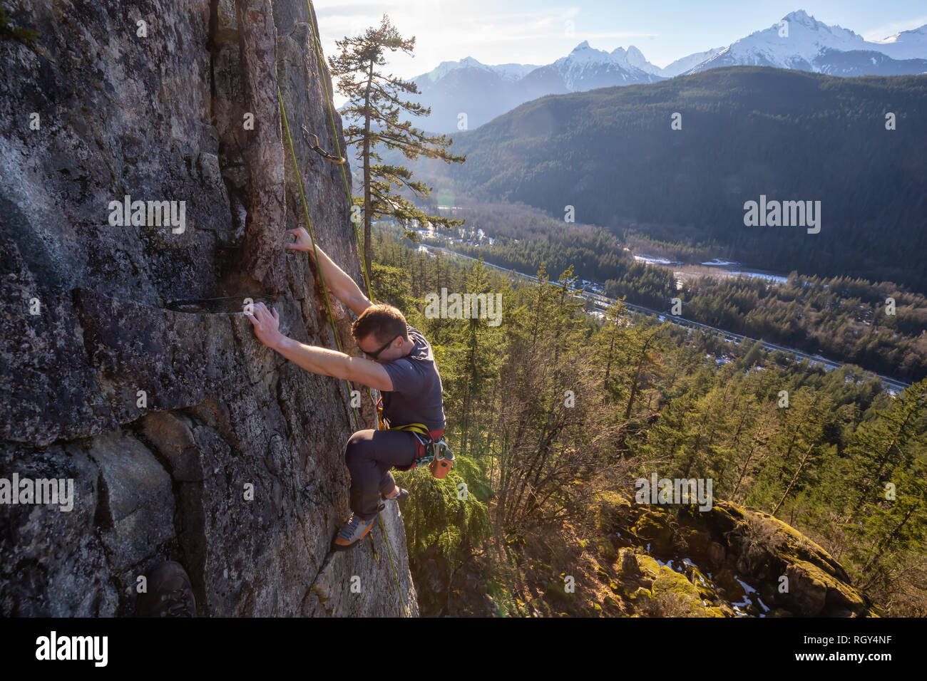 Männliche Kletterer Klettern auf dem Rand der Klippe während eines sonnigen Winter Sonnenuntergang. In Area 44 in der Nähe von Squamish und Whistler, nördlich von Vancouver, BC, Stockfoto