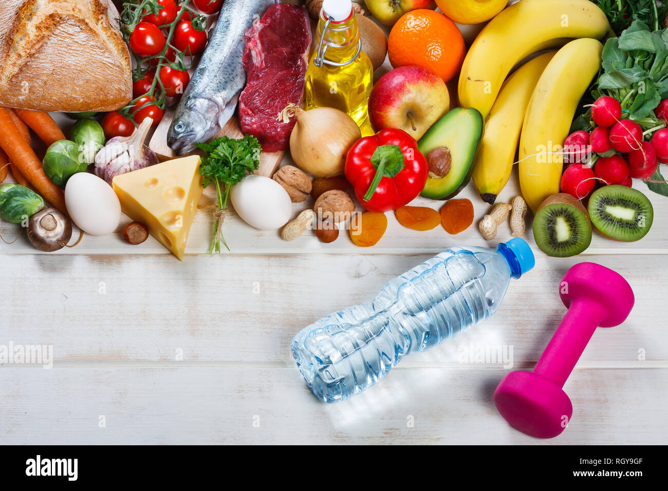 Gesunder Lebensstil und Gesundheit Konzept. Gesundes Essen, eine Flasche Wasser und Hantel auf Tisch Stockfoto