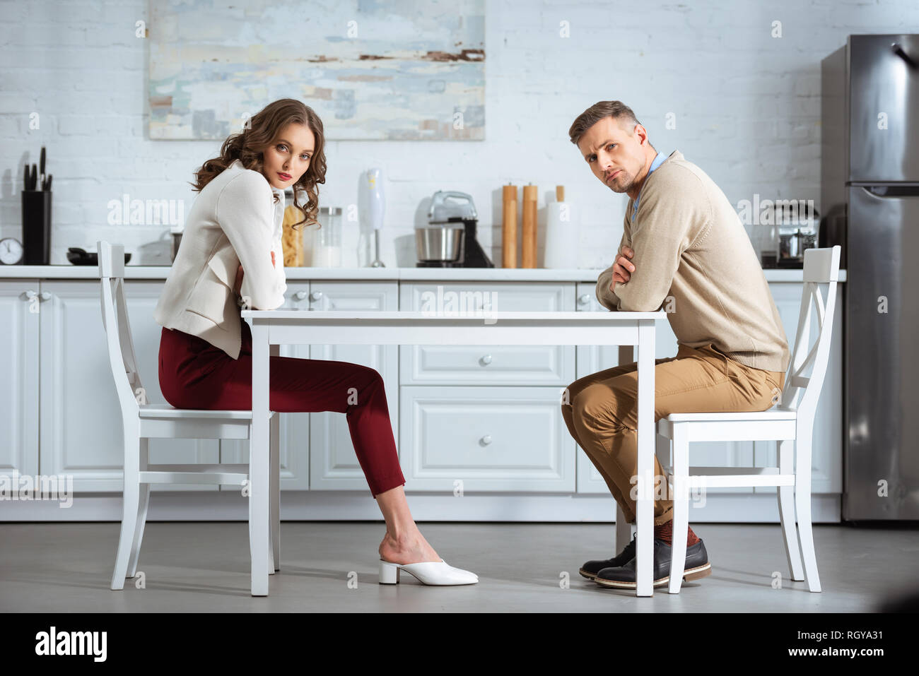 Unzufrieden Paar sitzen mit am Tisch in der Küche gekreuzt Stockfoto