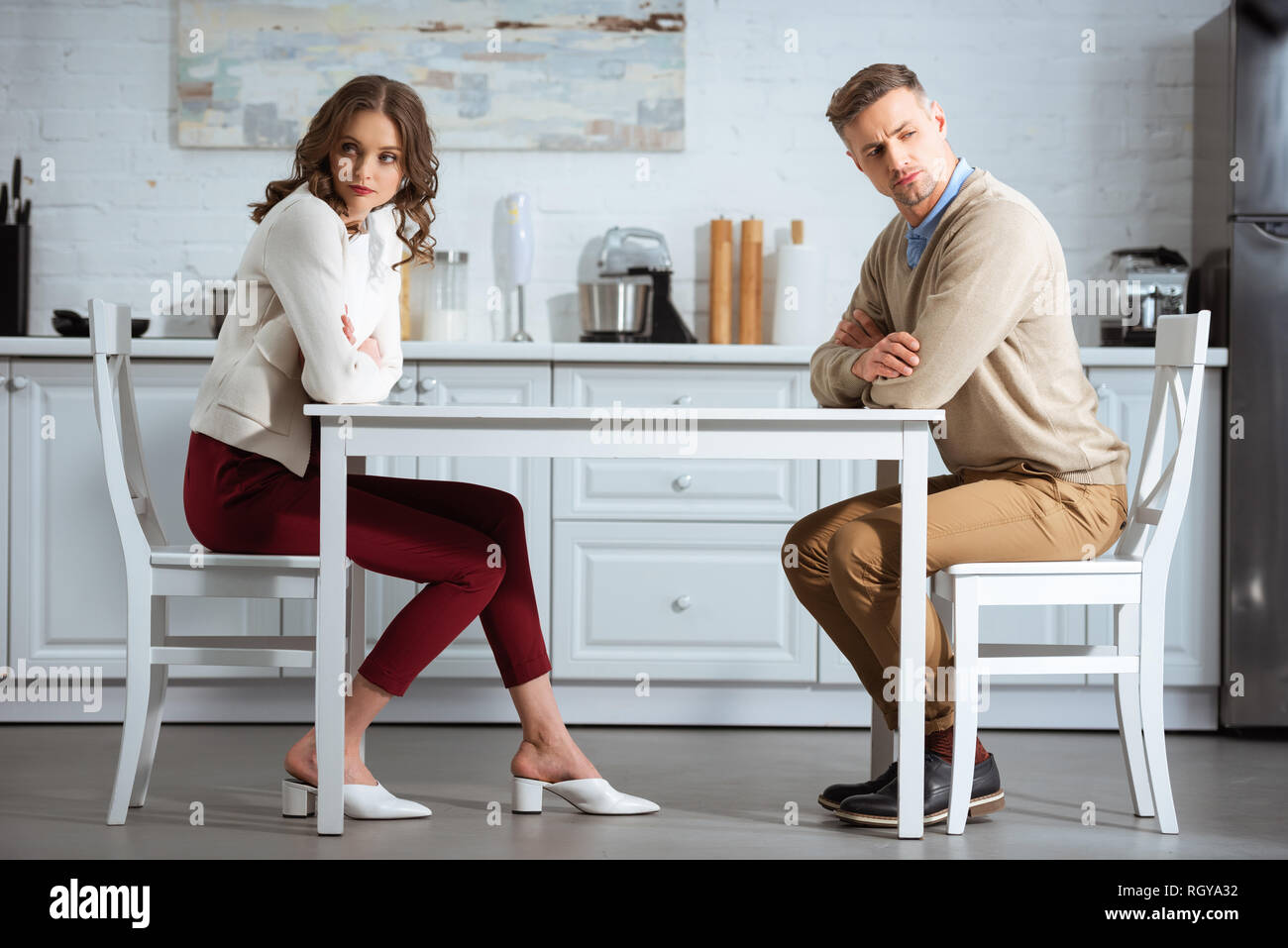 Unzufrieden Paar sitzen mit am Tisch in der Küche gekreuzt Stockfoto