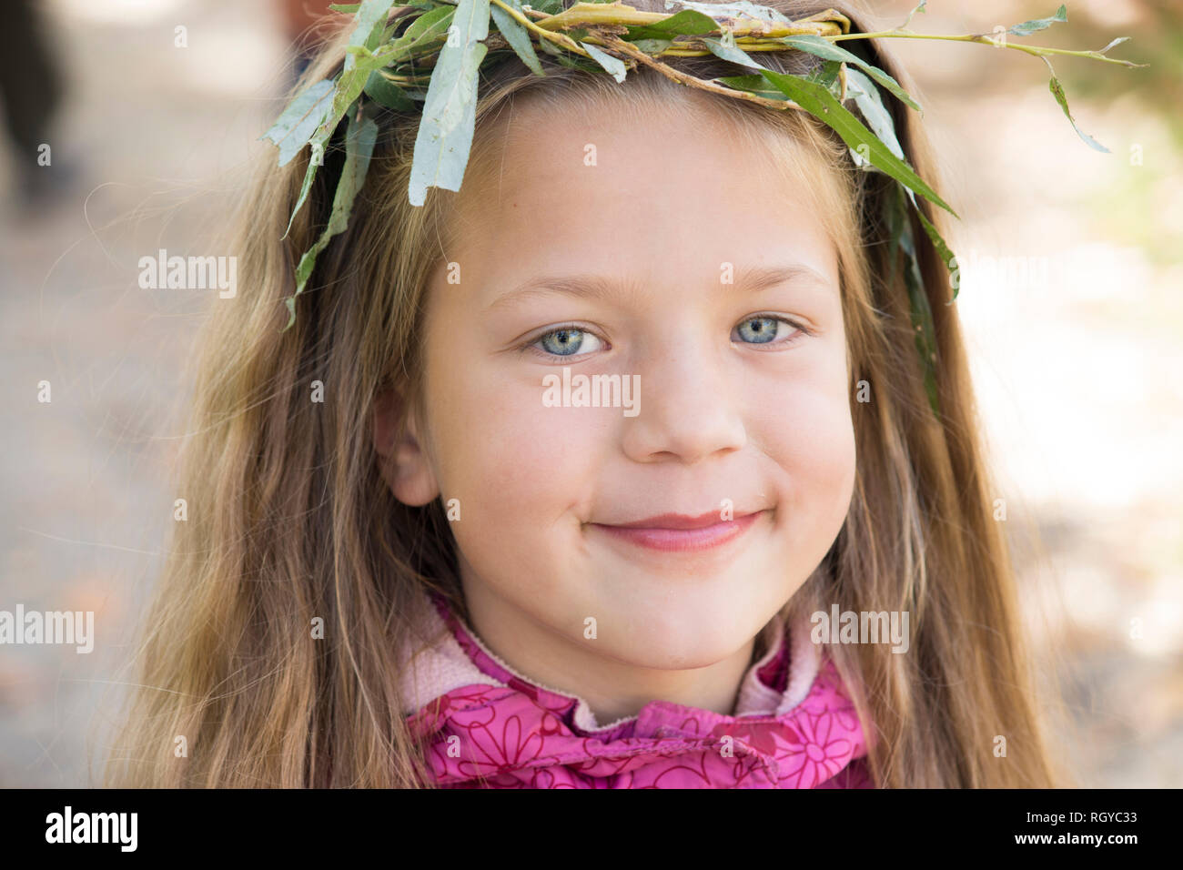 Lächelnde Mädchen tragen handgemachte Kranz aus Weide Zweigen Stockfoto