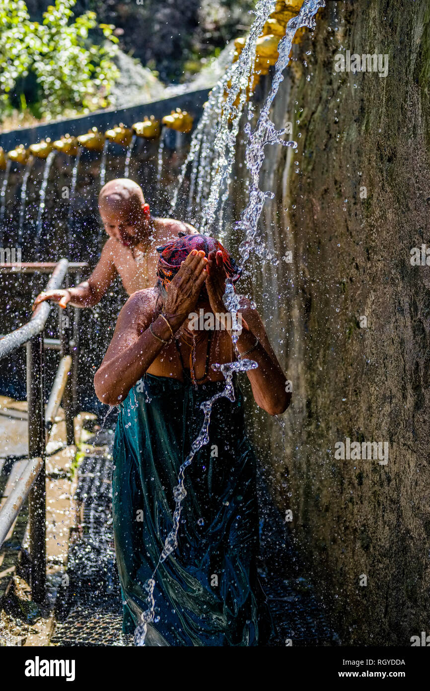 Pilger, die Dusche an der 108 Brunnen Ausgaben eiskalten heiligen Wasser in Muktinath Bügel Stockfoto