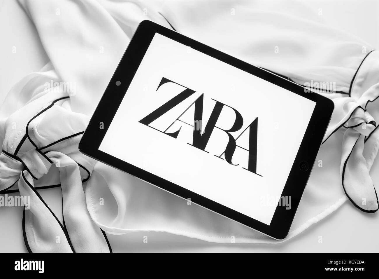 Galizien, Spanien; 30. Januar 2019: Zara neues Logo. Tablet-PC mit neuen curvy Schrift Logo auf Schwarz und weiße Bluse Stockfoto