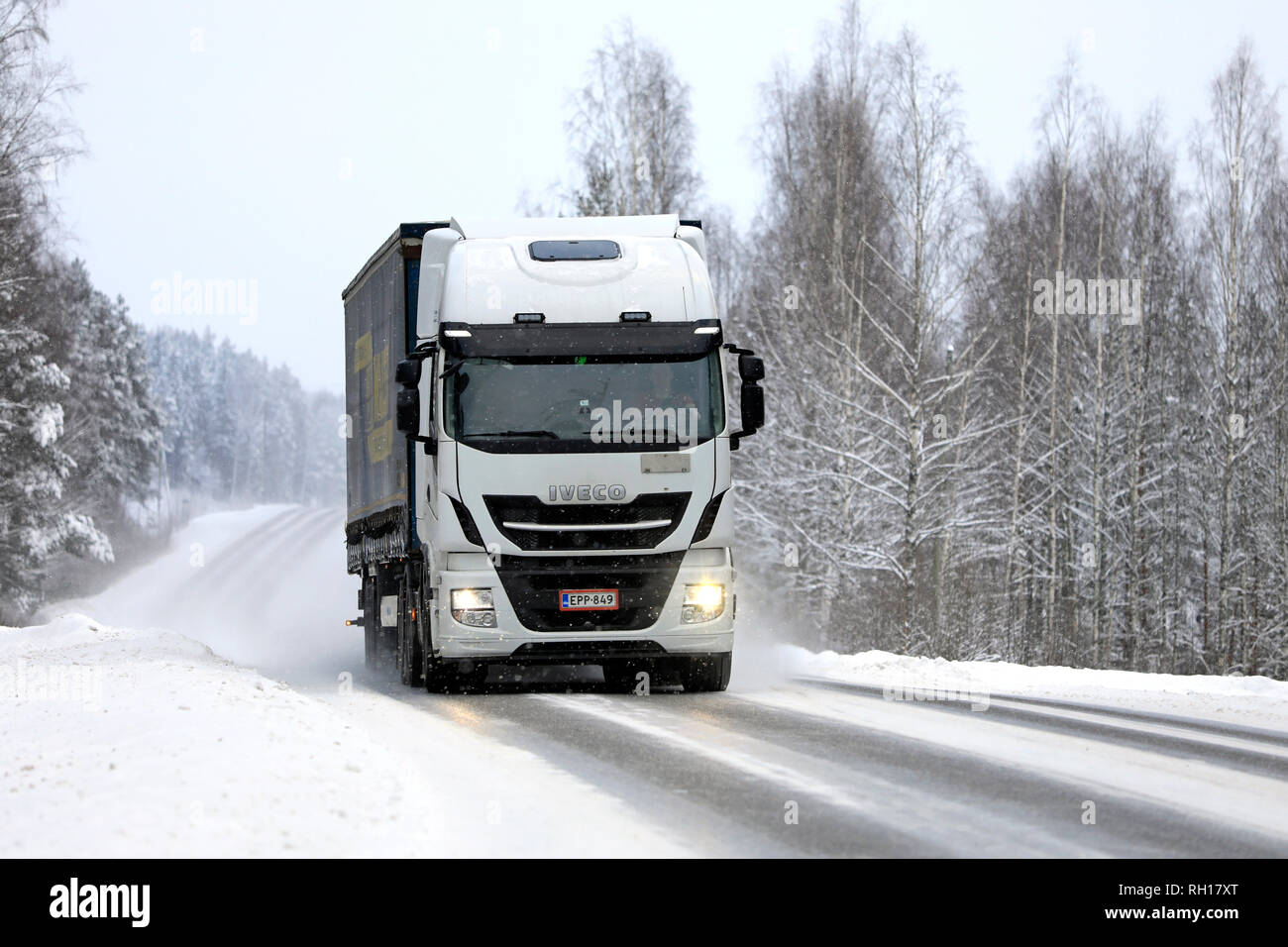 Salo, Finnland - Januar 27, 2019: Weiß Iveco Stralis truck zieht Trailer entlang der schneebedeckten Straße im Winter Schneefall im Süden Finnlands. Stockfoto