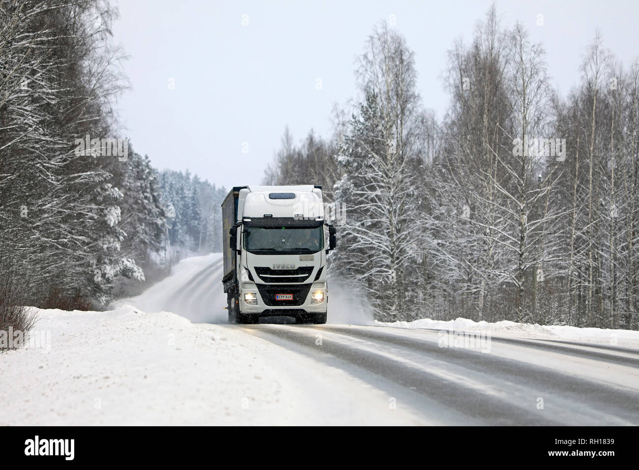 Salo, Finnland - Januar 27, 2019: Winter Landschaft mit weißen Iveco Stralis Güterverkehr Lkw im Schneefall. Stockfoto