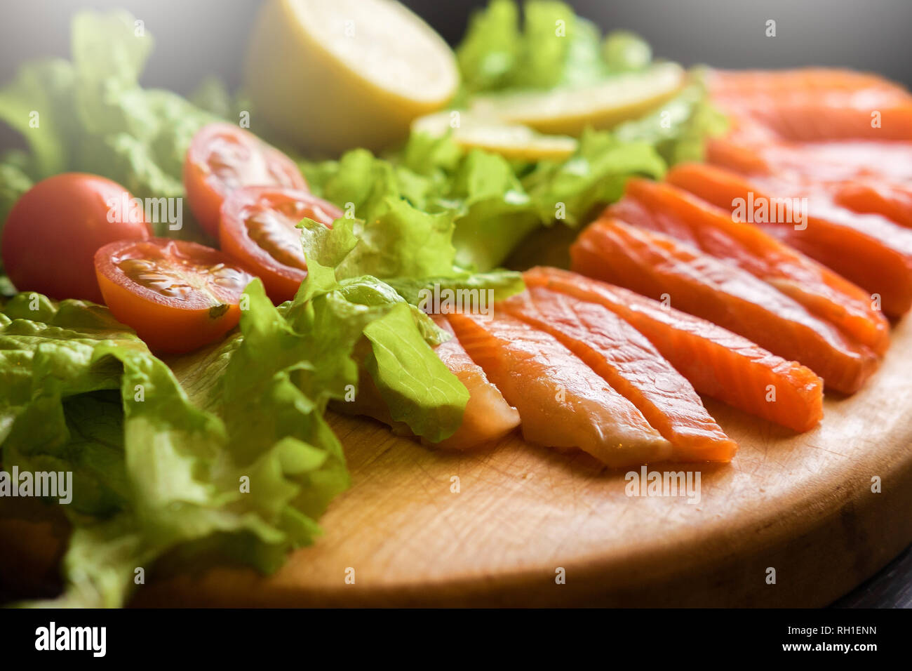 Stücke der roten Fisch grüner Salat Tomaten Zitrone Stockfoto