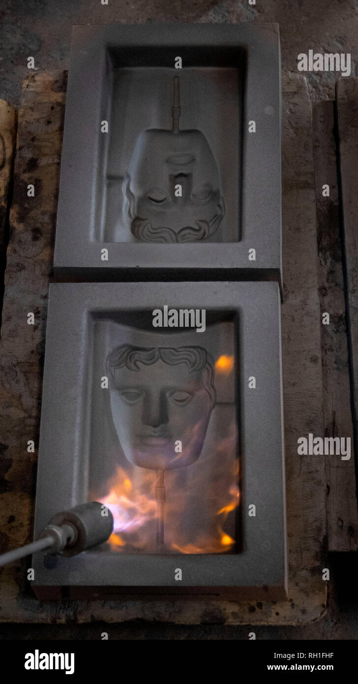 Der sand Gussteile werden in Brand gesetzt, wie sie bereit sind, für das Metall in der Hand gegossen zu werden - aus Gießen der Britischen Akademie für Film und Fernsehen Awards (BAFTA) Masken in einer Gießerei in West Drayton, London vor der Preisverleihung am 10. Februar. Stockfoto