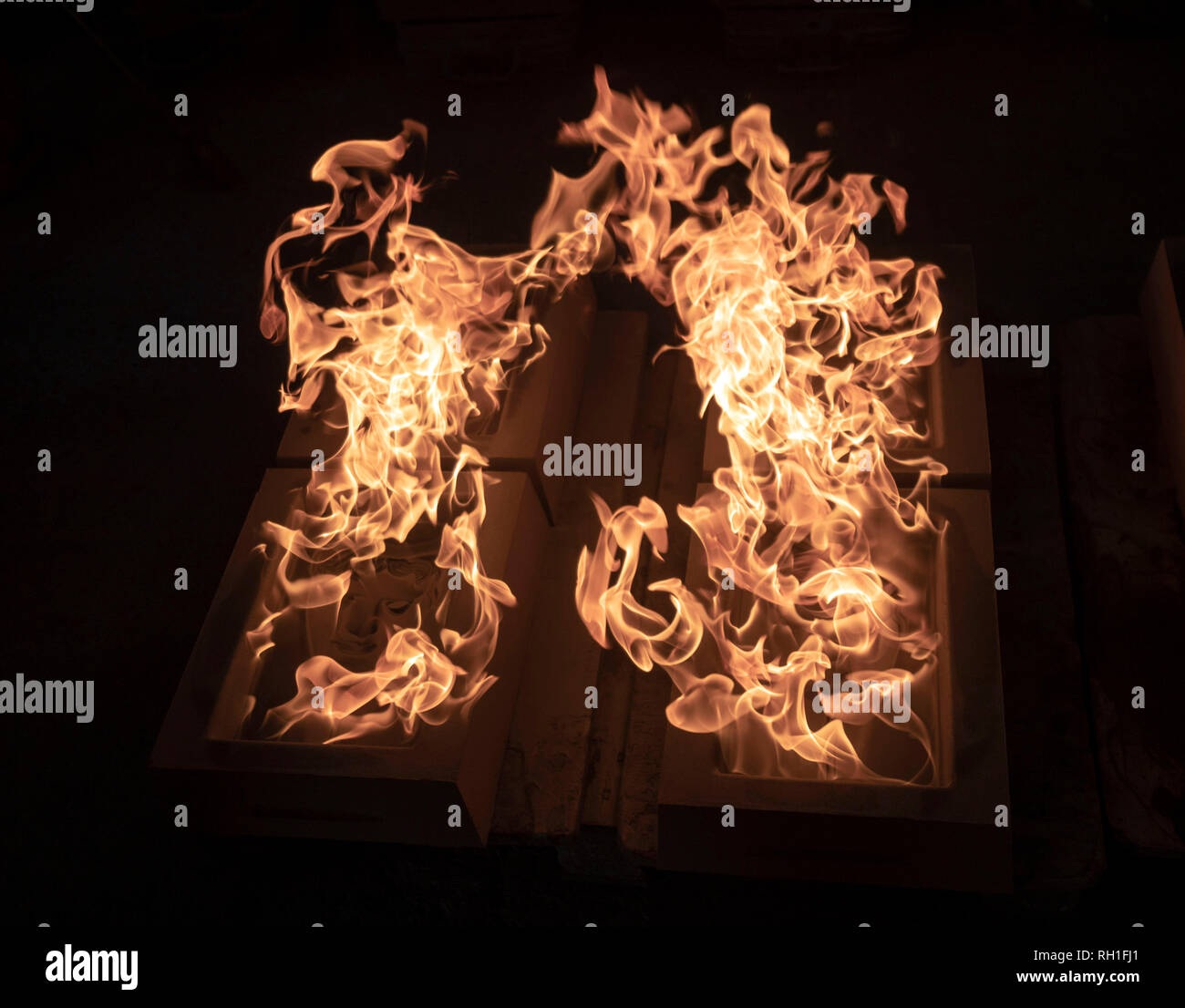 Der sand Gussteile werden in Brand gesetzt, wie sie bereit sind, für das Metall in der Hand gegossen zu werden - aus Gießen der Britischen Akademie für Film und Fernsehen Awards (BAFTA) Masken in einer Gießerei in West Drayton, London vor der Preisverleihung am 10. Februar. Stockfoto