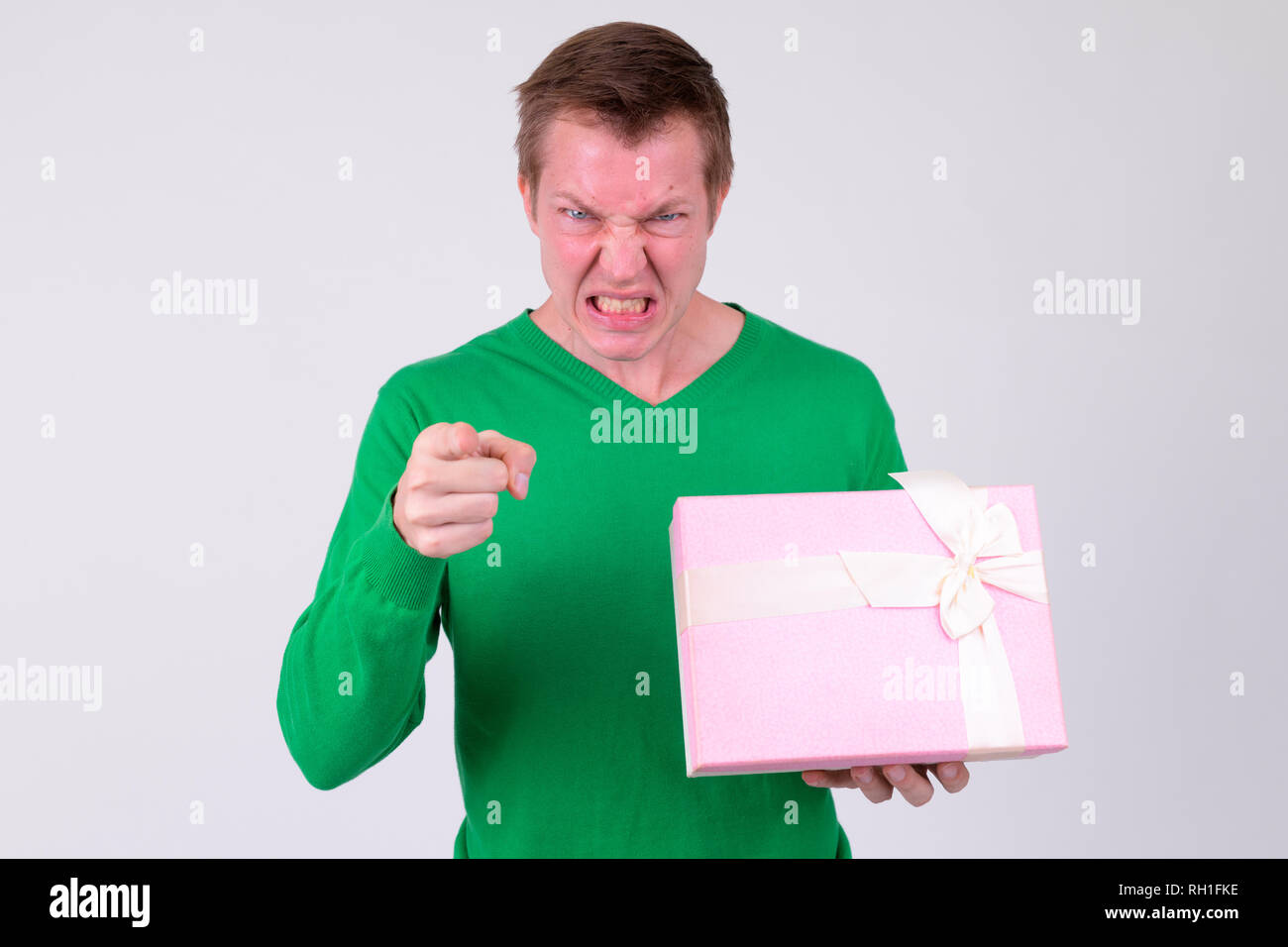 Zornigen jungen Mann, der auf der Kamera halten Geschenkbox Stockfoto