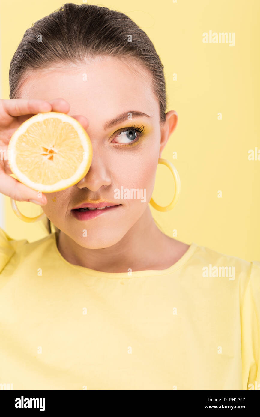 Schöne stilvolle Girl holding Zitrone, Beißen, Lippe und auf Limelight isoliert Posing Stockfoto