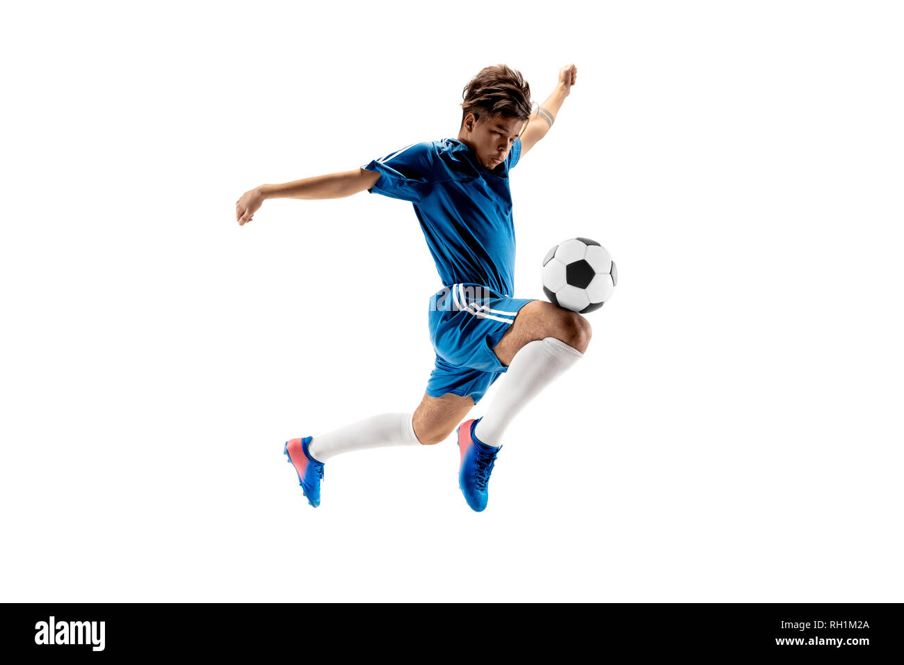 Junge mit Fußball zu tun Flying Kick, isoliert auf Weiss. Fußball-Spieler in Bewegung in Studio Hintergrund. Fit springen Junge in Action, Jump, Bewegung im Spiel. Stockfoto