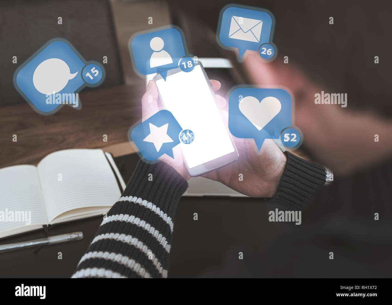 Mann mit Smartphone mit social media Benachrichtigungssymbole schweben über glühende Bildschirm Stockfoto