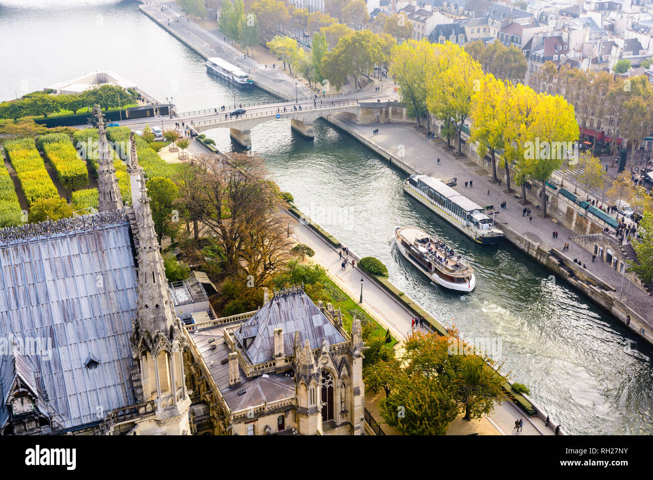 Luftbild vom Turm der Kathedrale Notre-Dame de Paris über den Fluss Seine mit tour Boote kreuzen und Menschen auf den Kaianlagen bummeln. Stockfoto