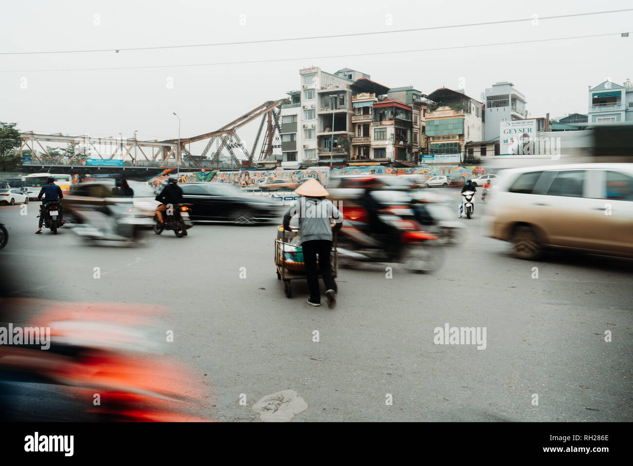 Das Leben der vietnamesischen Anbieter in Hanoi, Vietnam. Der Verkäufer versucht, die Straßen in verrückten Verkehr zu überqueren. Stockfoto