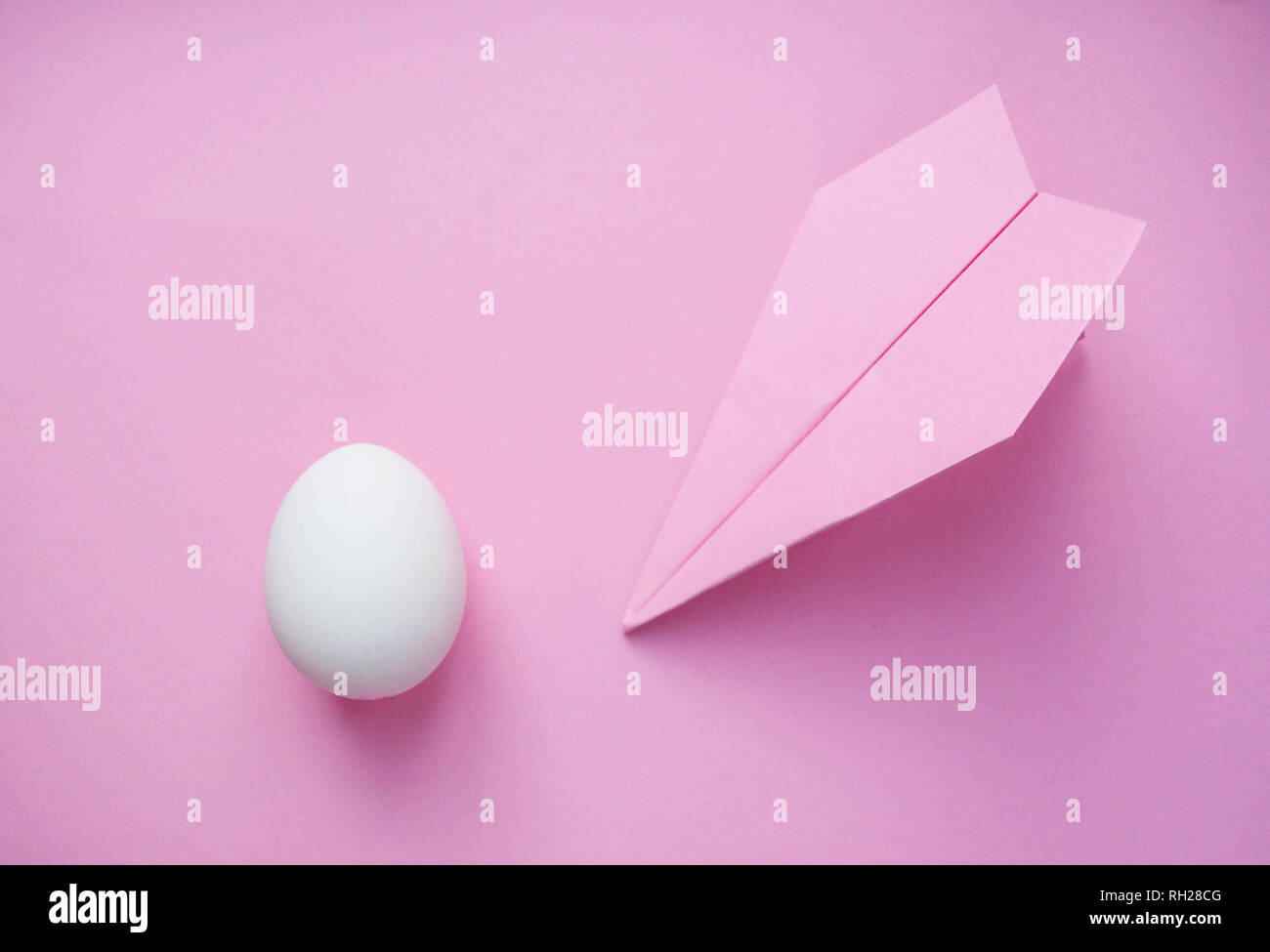 Eine weiße einziges Ei auf rosa Hintergrund mit Paper Plane und Copyspace. Travel Concept. Stockfoto