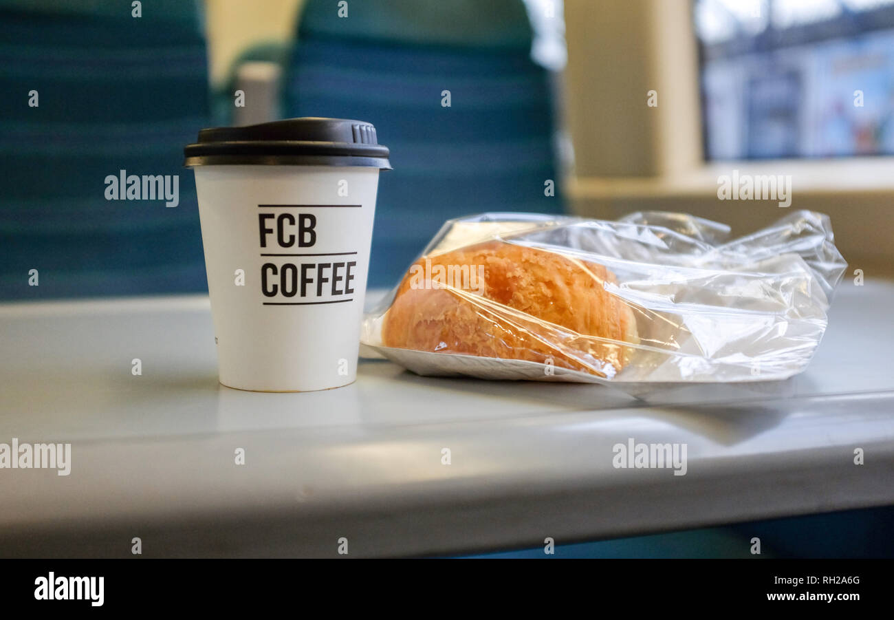 Einem takeaway FCB Tasse Kaffee und Gebäck auf einem Zug Stockfoto