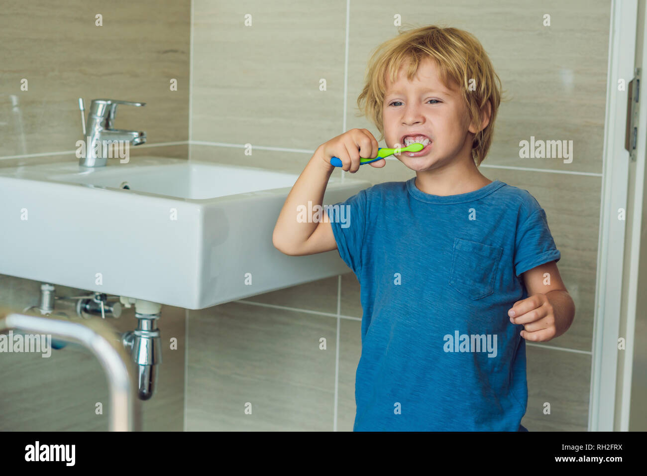 Kleine blonde Junge lernen seine Zähne putzen in der heimischen Badewanne.  Kinder lernen, gesund zu bleiben. Health Care Konzept Stockfotografie -  Alamy