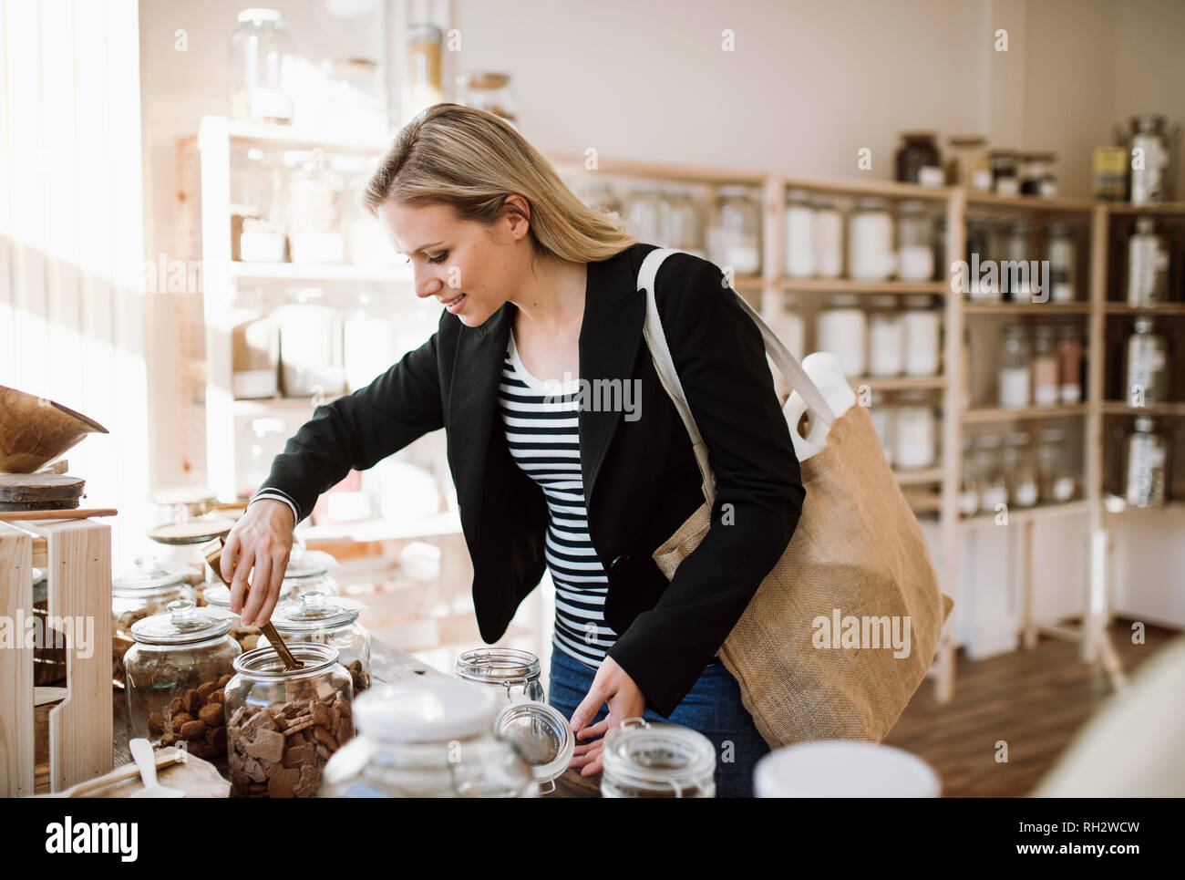 Eine attraktive junge Frau kaufen Lebensmittel in null Abfall Shop. Stockfoto