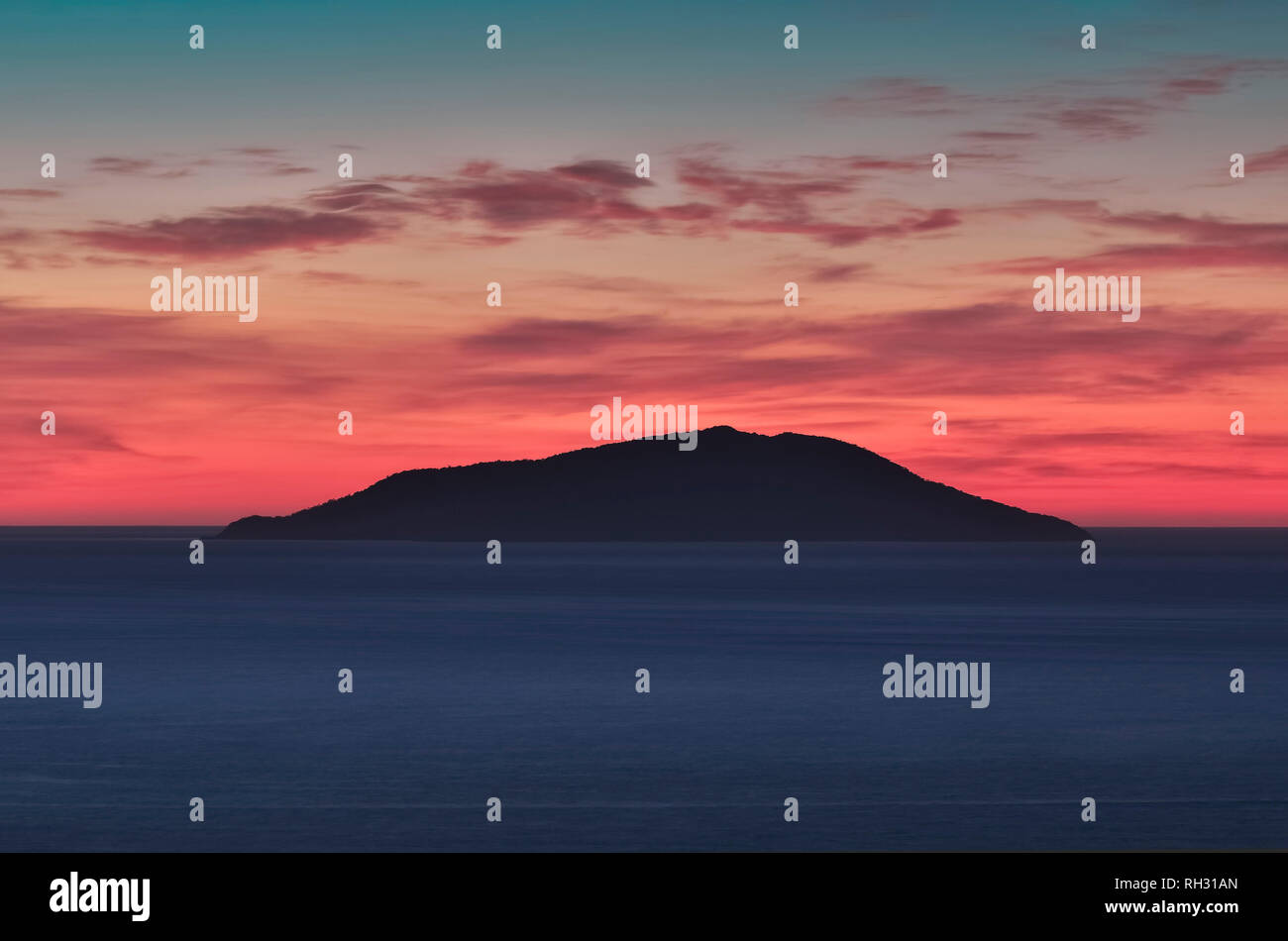 Kleine Insel Silhouette in der Mitte des Meeres bei Sonnenaufgang, bunte Himmel mit roten, Zyan und Blau Tönen. Ilha Do Arvoredo - Bombinhas SC, Brasilien. Stockfoto
