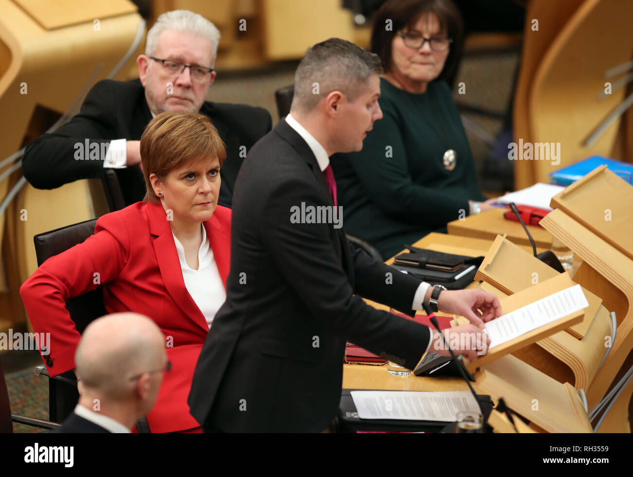 Erster Minister Nicola Sturgeon hört Finanzminister Derek Mackay während Phase 1 Haushaltsdebatte der Schottischen Regierung bei den schottischen Parlament in Edinburgh. Stockfoto