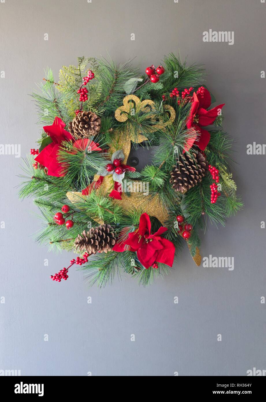 A Christmas wreath hängt in einer Vordertür während der Weihnachtszeit. Stockfoto