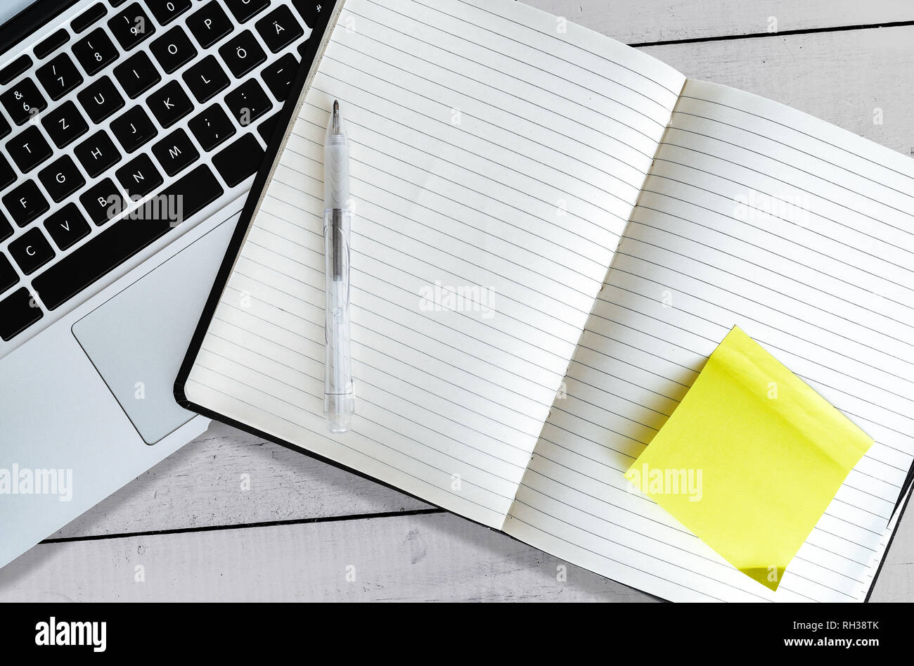 Leer, öffnen Sie die Anwendung "Notizen" mit gelben Haftnotiz neben Laptop auf weiße Holztisch Stockfoto