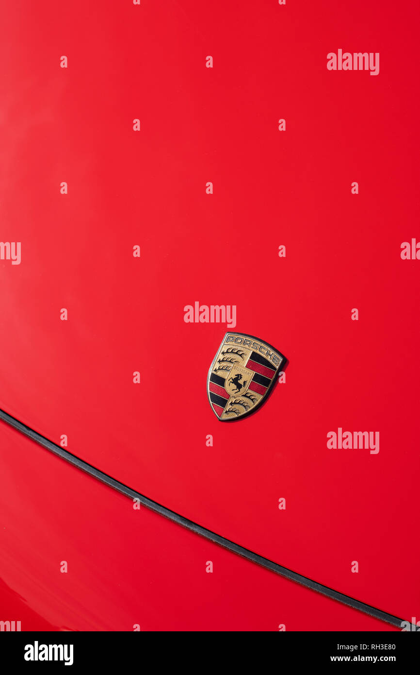 Porsche Car Badge auf eine rote Motorhaube Abstract Stockfoto